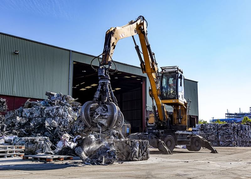 EMR Loading Scrap Metal into a Newton Steel Body Tipping Trailer for Scrap metal Transport in the UK